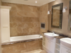 Master Ensuite - purpose made shelving unit at end of bath, marble tops and bath surround with tile TV
